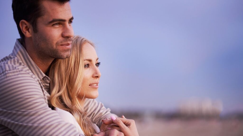 Pareja disfrutando de un abrazo al atardecer, simbolizando la conexión emocional en una relación.