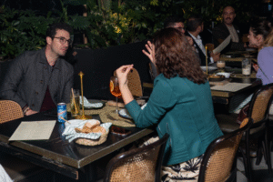 Pareja conectando en evento nocturno de Match Match Agency, rodeados de invitados internacionales.