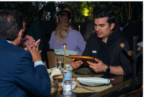 Pareja conectando en evento nocturno de Match Match Agency, rodeados de invitados internacionales.